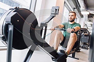 Active athlete man doing rowing workout