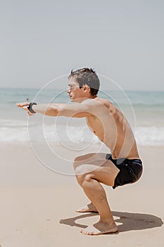 Active athlete runner running on sandy beach. Man long jumping at ocean, sprinting with high energy in outdoor cardio training.