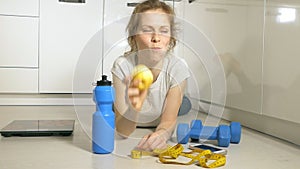 Active athletic sportive woman with towel in sport outfit eating apple after the training