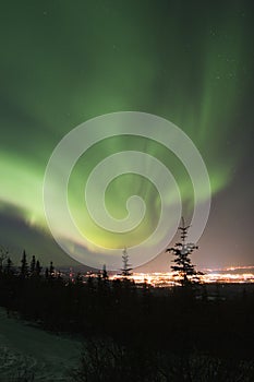 Active Aurora Borealis in the sky over town lights