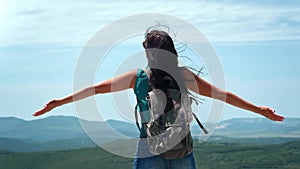 Active backpacker woman raising hands on top of high mountain slowmo. 4k Dragon RED camera