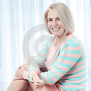 Active beautiful middle-aged woman smiling amiably, showing thumbs up and looking at the camera.