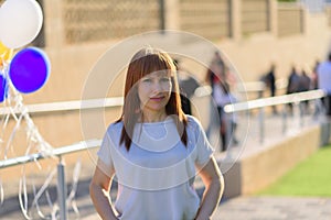 Active beautiful middle-aged woman smiling friendly and looking in camera in city street.