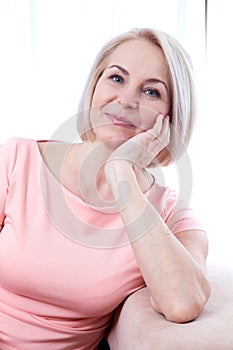 Active beautiful middle-aged woman smiling friendly and looking into the camera. Woman's face close up.