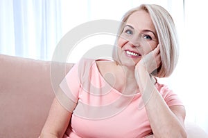 Active beautiful middle-aged woman smiling friendly and looking into the camera. Woman's face close up.