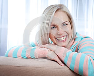 Active beautiful middle-aged woman smiling friendly and looking into camera. Woman's face close up.