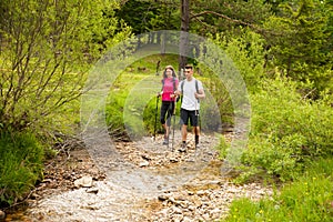 Active Beautiful young couple hiking ina nature climbing hill or