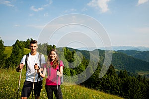 Active Beautiful young couple hiking ina nature climbing hill or