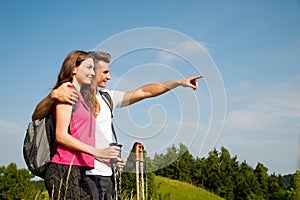 Active Beautiful young couple hiking ina nature climbing hill or