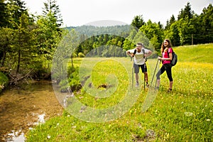 Active Beautiful young couple hiking ina nature climbing hill or