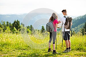 Active Beautiful young couple hiking ina nature climbing hill or