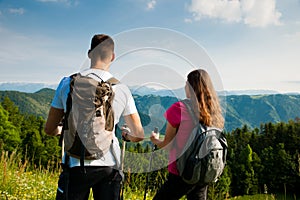 Active Beautiful young couple hiking ina nature climbing hill or