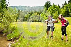 Active Beautiful young couple hiking ina nature climbing hill or