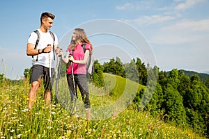 Active Beautiful young couple hiking ina nature climbing hill or