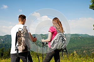 Active Beautiful young couple hiking ina nature climbing hill or