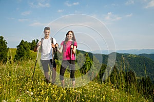 Active Beautiful young couple hiking ina nature climbing hill or