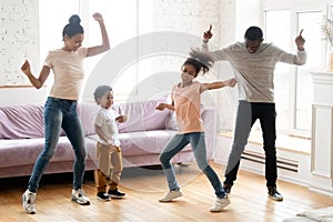 Active black family with children dancing at home