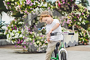 Active blond kid boy and bicycle near the sea. Toddler child dreaming and having fun on warm summer day. outdoors games for childr