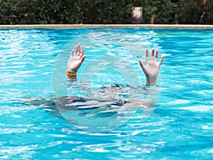 Active Boy diving and raising hands in the air at outdoor swimming pool