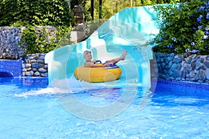 Active boy enjoying water slide in aquapark