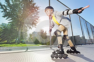 Active boy in helmet rollerblading at skate park