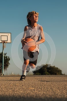 Active boy playing with basketball on court