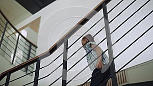 Active boy walking down stairs to hall. Preteen child jumping after lessons.