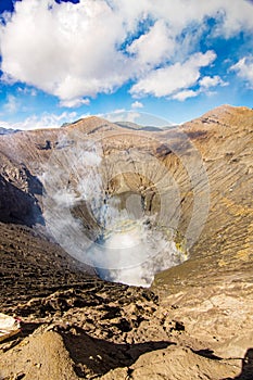 Active Bromo volcano mountain crater hole erupt with sulfur gas and smoke at Indonesia Bromo national park