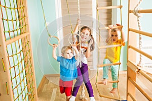 Active children excercising together at home training complex