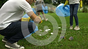 Active citizens collecting garbage in public park, society against pollution