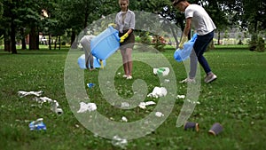 Active citizens collecting garbage in public park, society against pollution