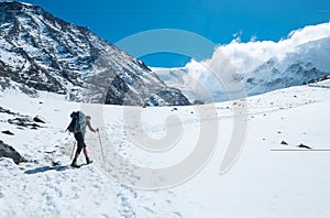 Active climber backpacker man with trekking poles and backpack climbing Mont Blank mount in French Alps mountains during high