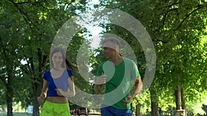 Active couple jogging together in summer park