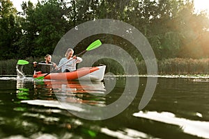 Active couple resting together, kayaking on the river on a sunny day during summer vacation