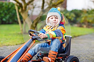 Active cute boy having fun with toy race cars