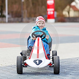Active cute boy having fun with toy race cars