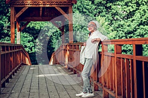 Active dame standing on the brown wooden bridge