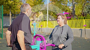 Active elderly couple exercising outdoors in a park or garden,