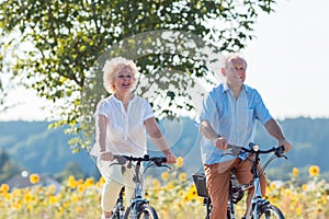 Active elderly couple riding bicycles together in the countrysid