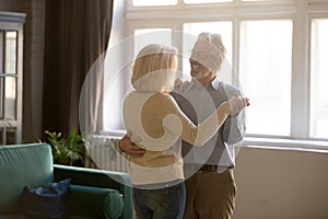 Active elderly wife and husband dancing at home