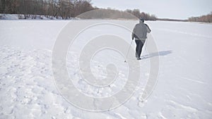 Active an elderly woman engaged in Nordic walking with sticks in the winter forest. Healthy lifestyle concept. Mature