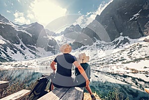 Active family leisure, spring summer hiking. Father and son rest near the mountain lake