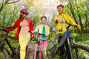 Active family with mountain bikes walking in park