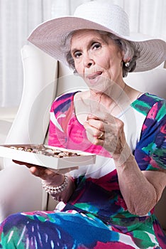 Active female senior earing chocolate candy photo
