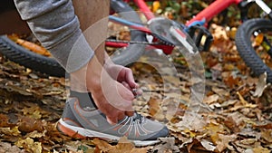 Active fit man tying shoe in the park. slow motion