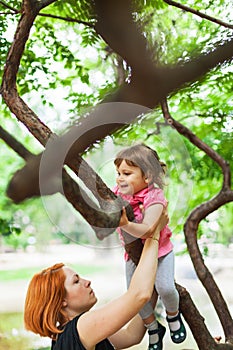 Active girl climbing on tree