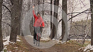 Active girl cycling with her dog. Sporty girl riding a bike in nature.