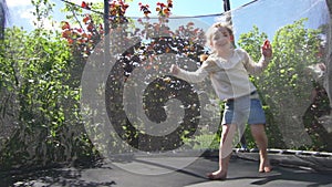 Active girl doing tricks jumping on trampoline. Handheld shot