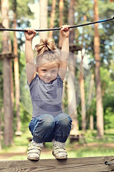 Active girl hanging on a rope in the park