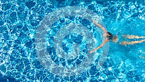 Active girl in swimming pool aerial drone view from above, young woman swims in blue water, tropical vacation